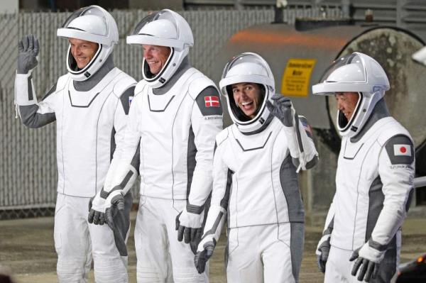 TOPSHOT - (From L) Roscosmos cosmo<em></em>naut Ko<em></em>nstantin Borisov, European Space Agency (ESA) astro<em></em>naut Andreas Mogensen, NASA astro<em></em>naut Jasmin Moghbeli, and Japan Aerospace Exploration Agency (JAXA) astro<em></em>naut Satoshi Furukawa,  wearing SpaceX spacesuits wave as they prepare to depart the Neil  A. Armstrong Operations and Checkout Building for Launch Complex 39A to board the SpaceX Dragon spacecraft.