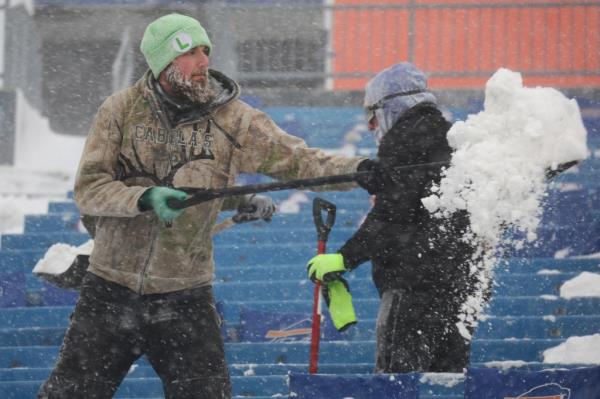 Workers remove snow from Highmark Stadium in Orchard Park, N.Y., on Jan. 14, 2024. 