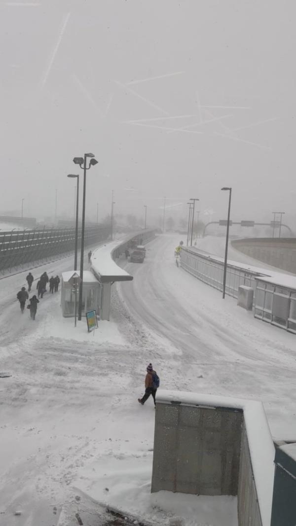 People walking amid snow are seen through a glass panel, at the Buffalo Niagara Internatio<em></em>nal Airport, in Buffalo, New York, on Jan. 14, 2024. 