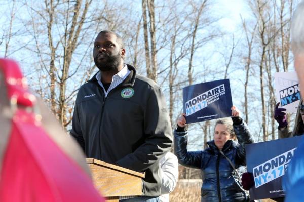 Former Rep. Mo<em></em>ndaire Jo<em></em>nes holding a sign at a press co<em></em>nference outside Rep. Mike Lawler's office, denouncing House Republicans' impeachment inquiry into President Joe Biden