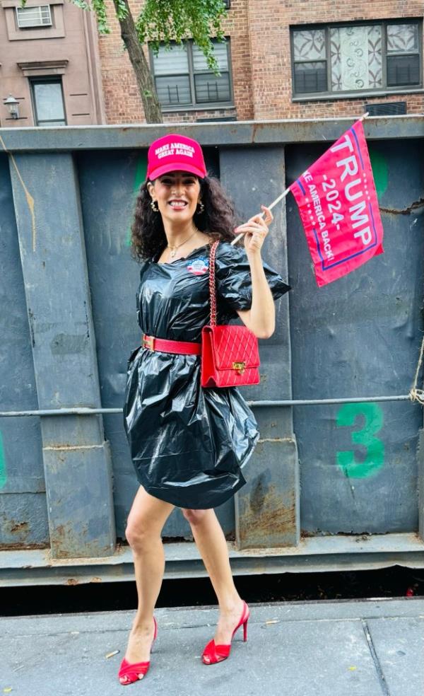 Sophie Sassoon posing with a MAGA hat and a trash bag